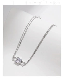 Close-up of a double-layer silver bracelet featuring a geometric rectangular stone