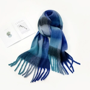 Detail shot of a thick mohair scarf featuring blue gradient checkers and soft tassels