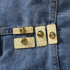 Golden metal butterfly clutch and pin back on blue denim for five-star badges
