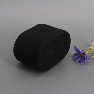 Detail view of a black velvet watch pillow for jewelry display with a purple flower