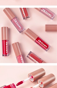 Close-up of velvet lip gloss applicator brushes and transparent tubes in pink shades