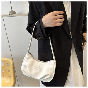 Detail of white pleated underarm bag with Fashion & Bag label on model outfit