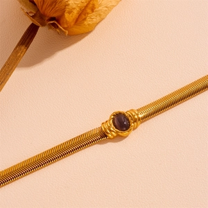 Elegant gold herringbone snake chain bracelet with a purple oval cat eye stone