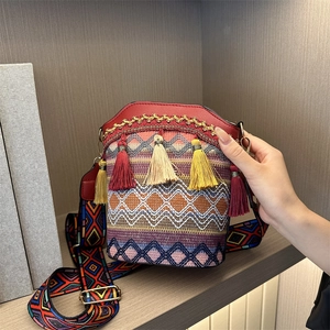 Ethnic woven bucket bag with colorful geometric patterns and decorative tassels