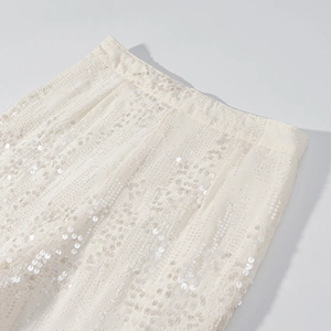 Dettaglio dei pantaloni con paillettes albicocca in tessuto mesh e cuciture di qualità