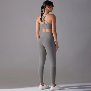 Detail showing cross-back sports bra and high-waist yoga leggings in matte grey fabric