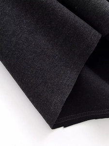 Detailed macro view of black fabric texture and high-quality edge stitching on dress