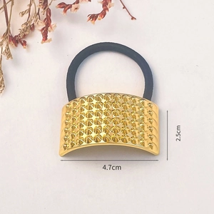 Detailed view of golden alloy hair ring with conical stud texture and size dimensions