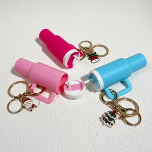 Detailed view of mini cup keychains with Christmas charms and internal straw structure