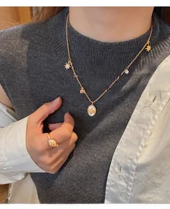 Détail d'un collier plaqué or 18 carats avec pendentif en relief étoilé porté sur un mannequin