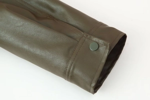 Detail of faux leather sleeve with olive green grain texture and single button closure