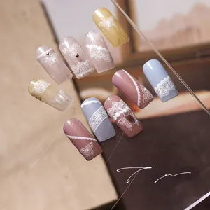 Detail showing 3D butterfly nail charms with lace patterns and pearl accents