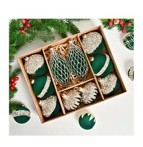 Detail of green and gold flocked Christmas ornaments set in a gift box with pine branches