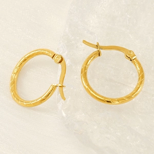 Gold plated titanium steel hoop earrings with textured spiral design on white backdrop