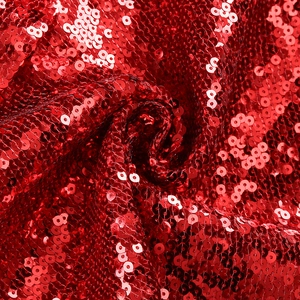 Gros plan sur le tissu brodé de paillettes rouge vif avec fini métallique brillant