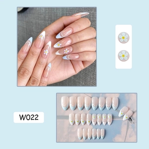 Close-up of nude pink French tip press-on nails with white daisies and light blue patterns