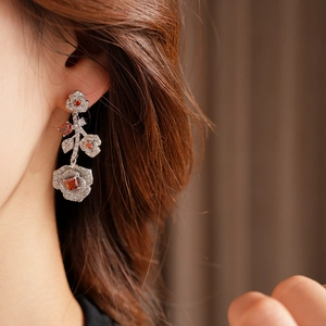 Macro shot of silver zircon rose drop earrings worn to show elegant vintage floral details