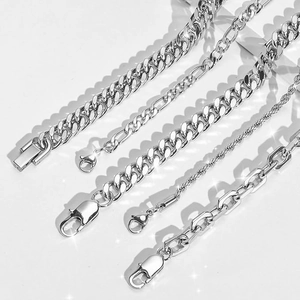 Detailed view of silver stainless steel Cuban, Figaro, and link chain bracelets set