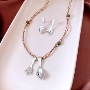 Detailed set of silver spoon and fork pendants with brown beaded woven rope necklaces