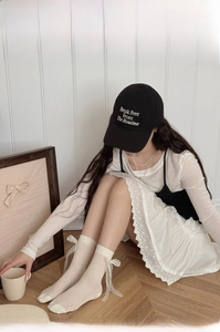 Close-up of white Lolita crew socks featuring delicate lace trim and ribbon bow details