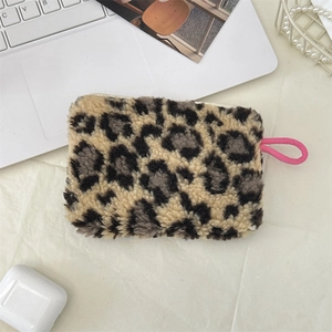 Plush leopard print coin purse with a vibrant pink zipper puller on a desk