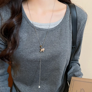 Detailed view of horse pendant with tiger eye stone and pearl on silver necklace