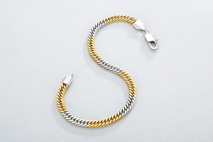 Detailed view of dual-tone gold and silver Cuban chain link bracelet with lobster clasp