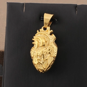Detailed close-up of golden anatomical heart pendant with realistic vascular texture