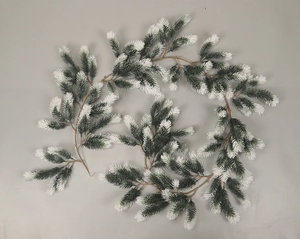 Detail of green PE Christmas garland with white frosted snow tips and flexible brown stem