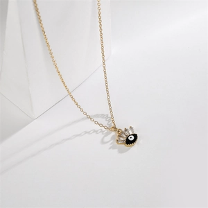 Detail of gold evil eye pendant with black enamel and micro-set cubic zirconia crystals