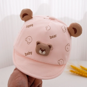 Detailed view of baby cap with cute 3D bear ears and soft pink cotton texture