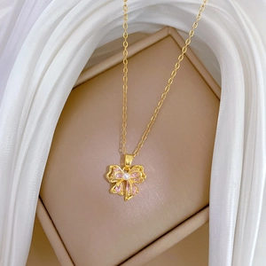 Elegant gold titanium necklace with pink crystal bow pendant and central pearl accent