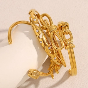 Detail of 18K gold plated stainless steel bangles featuring bow and floral patterns