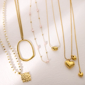 Exquisite gold layered necklace set with heart charms and white pink beaded details