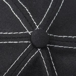 Close-up of black cotton baseball cap top button with white contrast stitching details