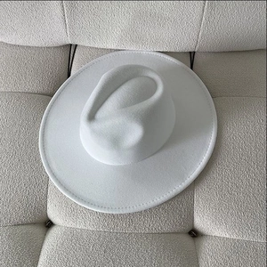 Vue de dessus d'un chapeau en feutre blanc à bord large sur un canapé en tissu