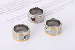 Detailed view of heart-shaped crystal rings in red and blue on a vintage paper background
