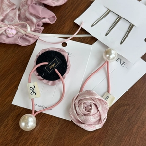 Detailed shot of pink floral silk rose hair scrunchie with large pearl and metal hair clip