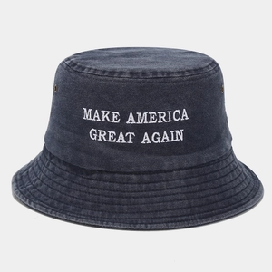 Détail d'un chapeau bob en denim lavé bleu marine avec broderie de texte blanc sur le devant