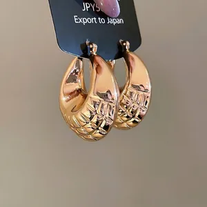 Chic gold-plated geometric hoop earrings with textured lattice design on card