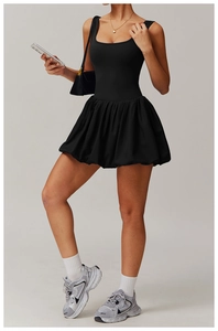 Detailed view of black athletic dress featuring U-neck sleeveless top and pleated hem