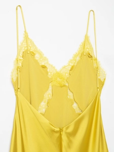 Détail de la robe en satin jaune avec dos nu et broderie en dentelle délicate