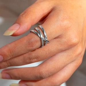 Detailed view of the layered twisted geometric stainless steel ring on model hand