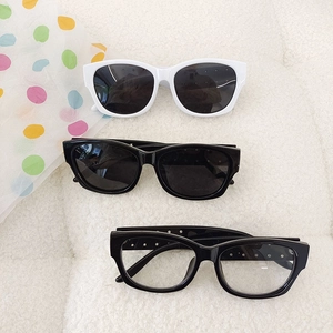 Kids trendy UV400 sunglasses set in black and white frames on soft texture background
