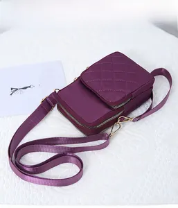 Detail of purple nylon crossbody phone bag with quilted texture and double zip compartments