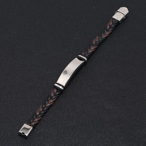Top view of black and brown braided leather bracelet with rectangular silver metal plate