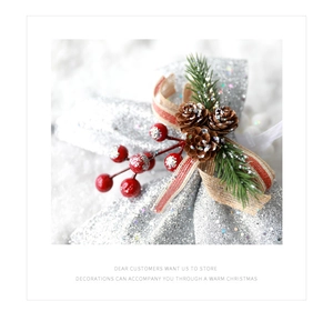 Close-up of a silver glitter bow with red berries, pine cones, and pine needles decor