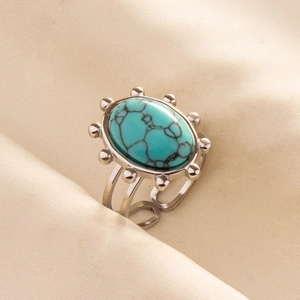 Macro shot of an adjustable stainless steel ring with oval turquoise stone and beaded edges