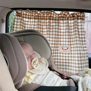 Close-up of brown plaid cotton car sunshade curtain with a cute smiley baby label