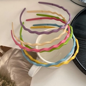 Close-up of wavy plastic headbands in assorted colors with anti-slip inner teeth